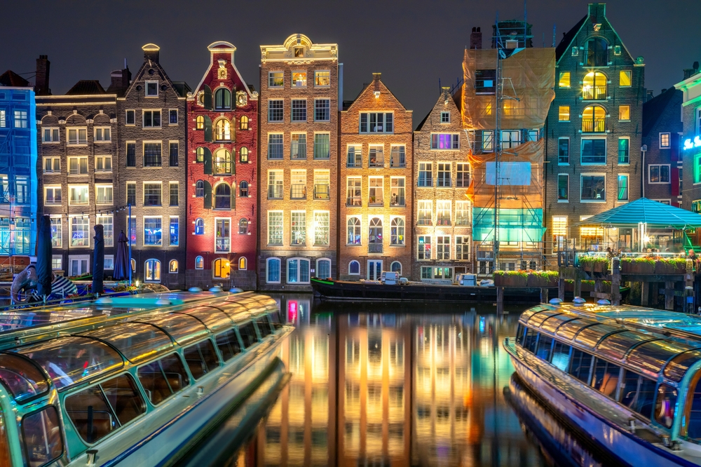 Famous old houses of Amsterdam. The houses stand in the water and have a beautiful reflection. Touristic district Damrak. These houses are famous all over the world. Amsterdam, Holland, Europe